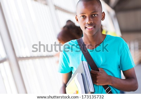 good looking african american college boy holding books