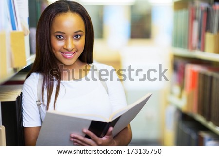 female afro american university student reading book in library