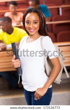 pretty young african american college student standing in classroom