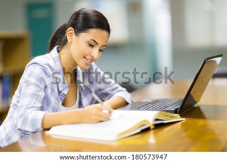 pretty college student studying a book in library pretty college student studying a book in library