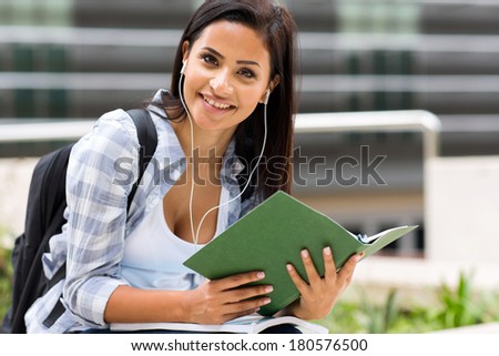 cute female university student listening music on campus