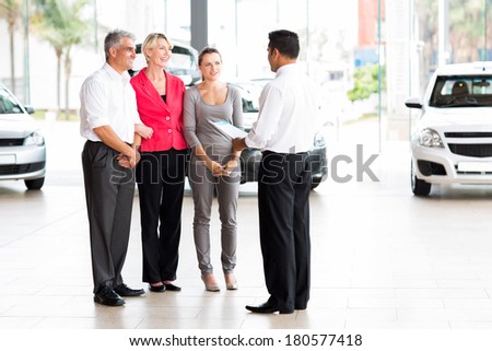 vehicle salesman explaining contract to family before purchasing a car