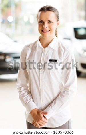 portrait of happy car saleswoman at car dealership
