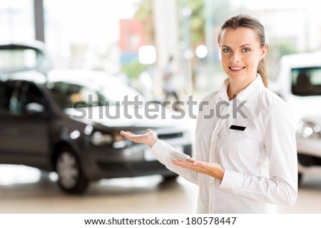 female vehicle sales consultant presenting new cars at dealership