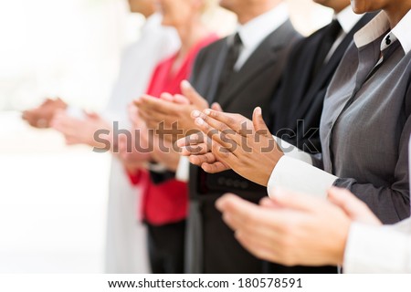 group of businesspeople clapping hands during meeting presentation