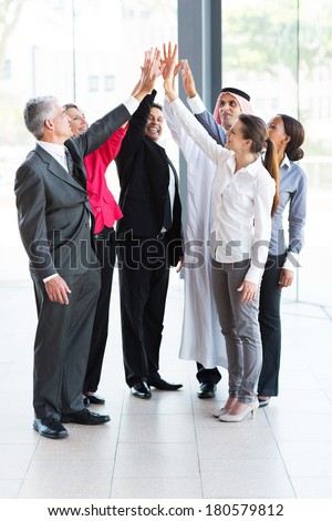 happy business team giving high five in office