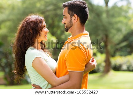 romantic young indian couple hugging outdoors in forest