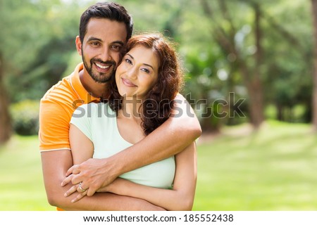 lovely young indian couple hugging outdoors