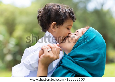 muslim mother kissing her baby boy close up muslim mother kissing her baby boy close up