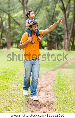 caring young indian father and son walking outdoors in forest