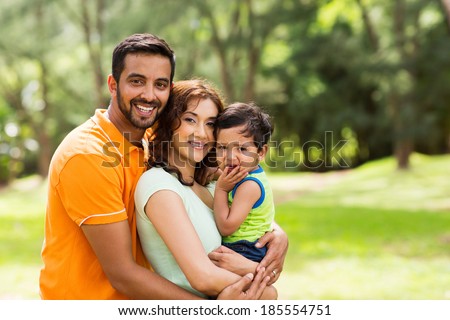 beautiful young indian family outdoors looking at the camera