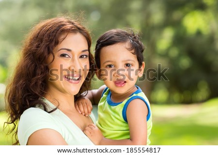 portrait of happy young indian mother and baby boy outdoors