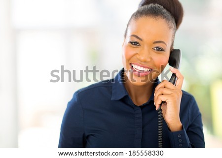 attractive african businesswoman using landline phone