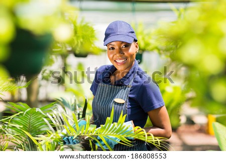 portrait of young afro american nursery worker gardening