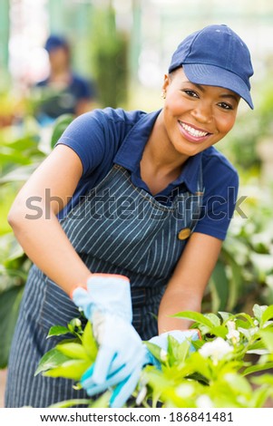 happy young african american nursery worker gardening