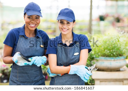 two pretty female florists portrait in greenhouse