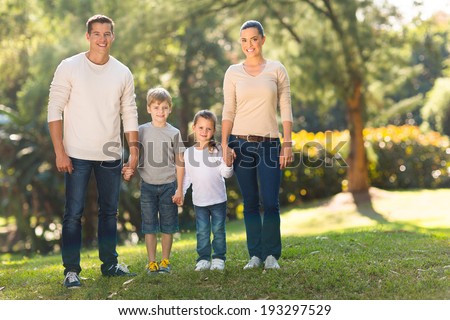 portrait of young family standing together outdoors