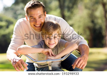 portrait of happy young father and son on a bike