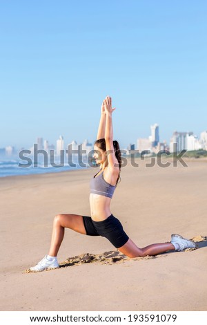 fit woman doing yoga exercise on beach
