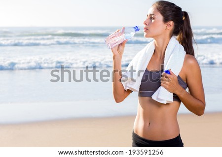 pretty woman drinking water after working out