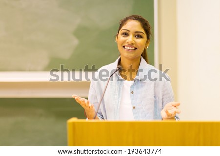 pretty indian female college student giving a speech in lecture hall