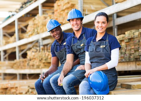 group of cheerful young hardware store co-workers resting at timber yard