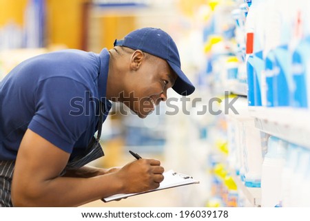 cheerful african hardware store worker taking stock