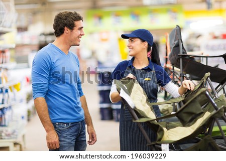 friendly saleswoman selling camping chair to customer in supermarket