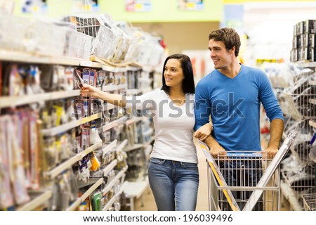 young couple buying padlock in hardware store