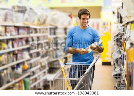 handsome young man shopping for tools at hardware store