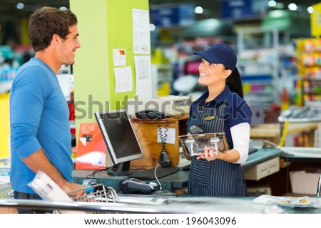 young man paying at till point in hardware store