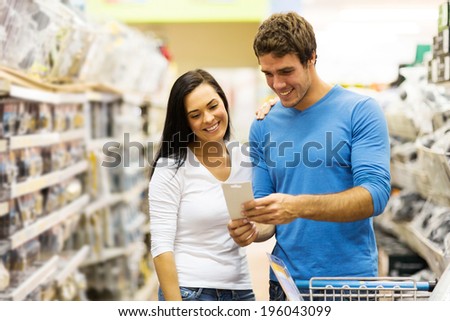 cheerful young couple shopping in hardware store