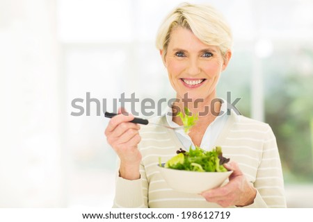 beautiful senior female vegetarian eating salad