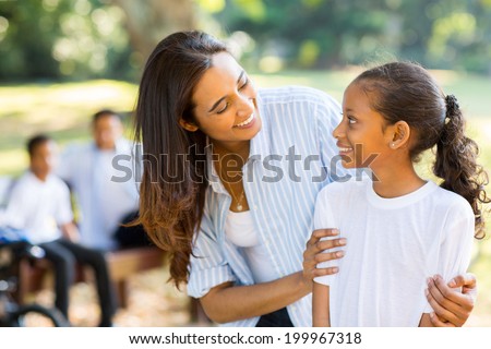 happy indian mother and cute daughter in front of family