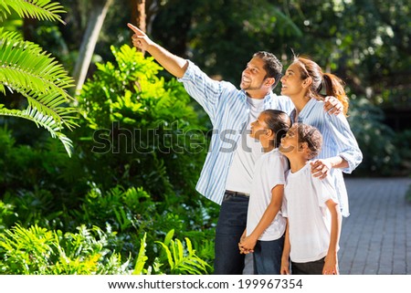 beautiful indian family looking and pointing in the park