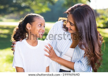 pretty indian mother talking to her beautiful daughter outdoors