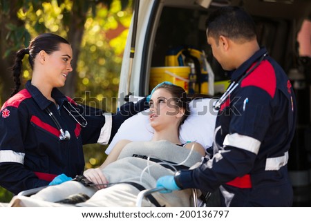 paramedic team talking to young patient before she going into an ambulance