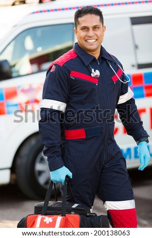 handsome young paramedic carrying portable equipment