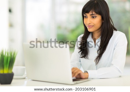 pretty indian businesswoman using computer in office