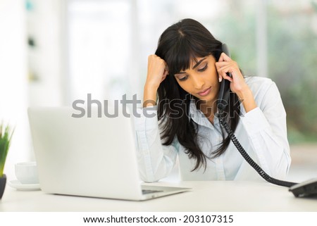 worried indian businesswoman receiving bad news over the phone