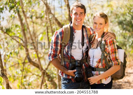 happy young couple hiking in autumn forest