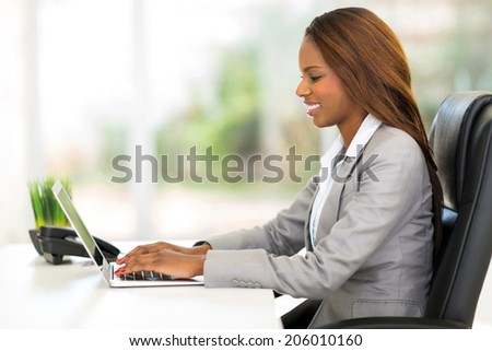 attractive african office worker using laptop computer