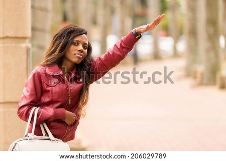 pretty african woman hailing a taxi cab