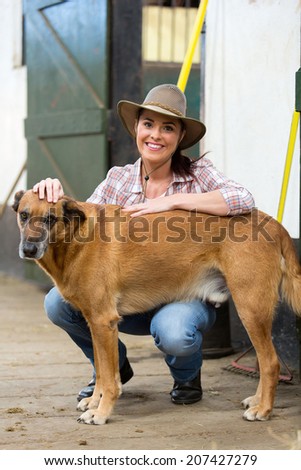 cheerful cowgirl and her dog inside farm house