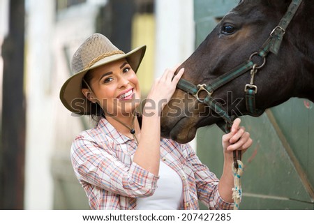 happy cowgirl and her horse in stable