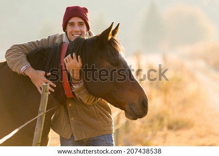 portrait of happy man hugging his horse in the ranch