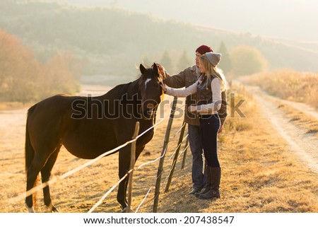 beautiful couple petting horse in the ranch