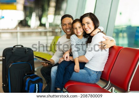 loving young family waiting for their flight at airport