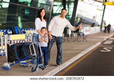 family hailing for a taxi after arriving at airport
