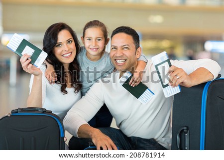 happy family holding boarding pass and passport at airport